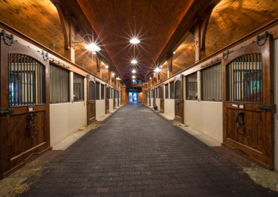 horse stall section of large horse barn with wooden stall doors